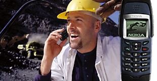 Foto de un obrero utilizando un tel&eacute;fono m&oacute;vil.